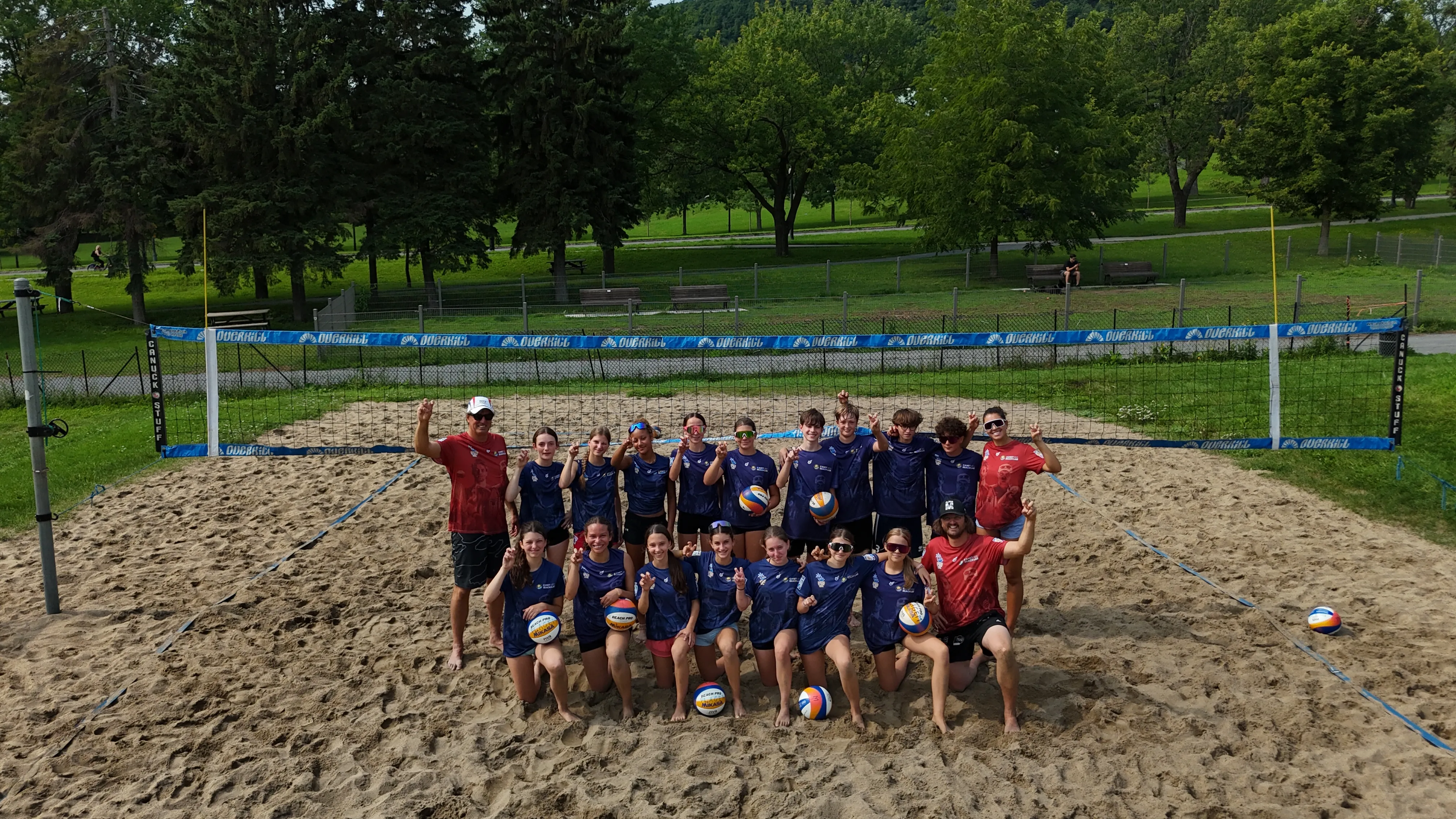 Participants du camp d'été international Plage M 2026 réunis sur un terrain de sable du parc Jeanne-Mance